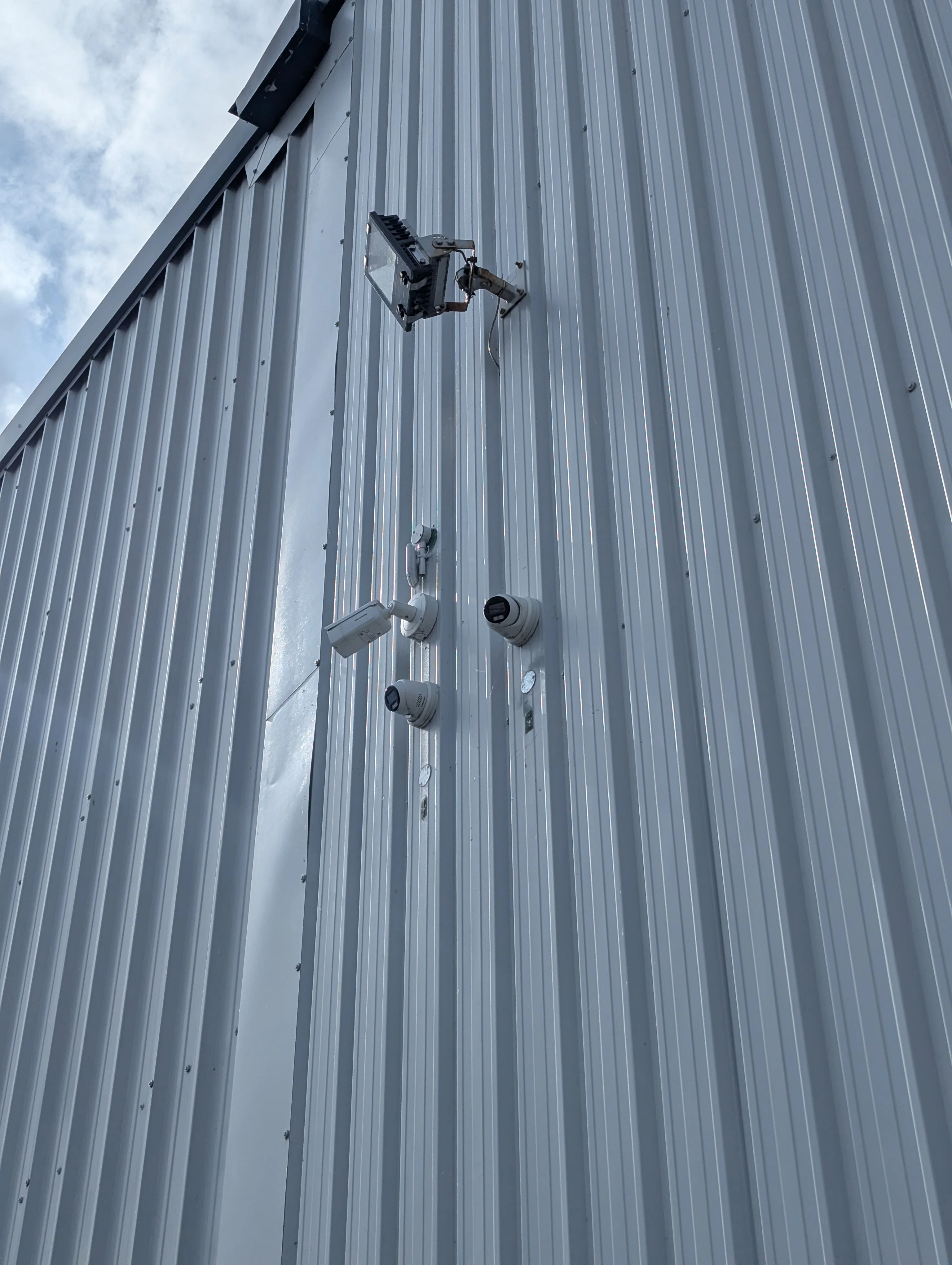Hikvision CCTV cameras installed high on a commercial building for site security.