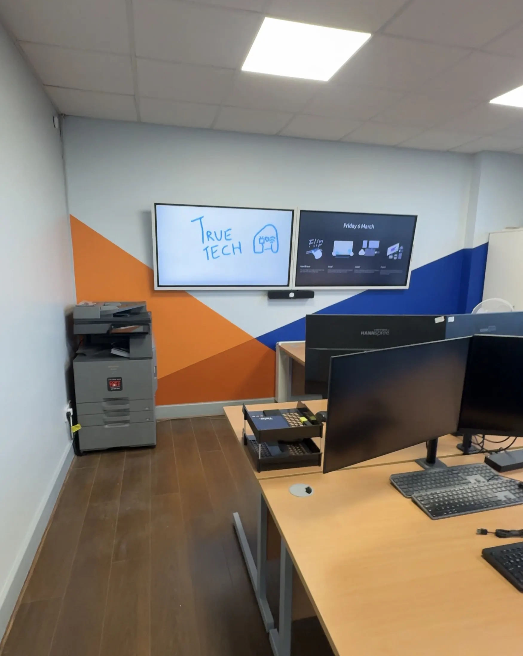 Commercial dual screen office AV installation with clean cabling and display setup.