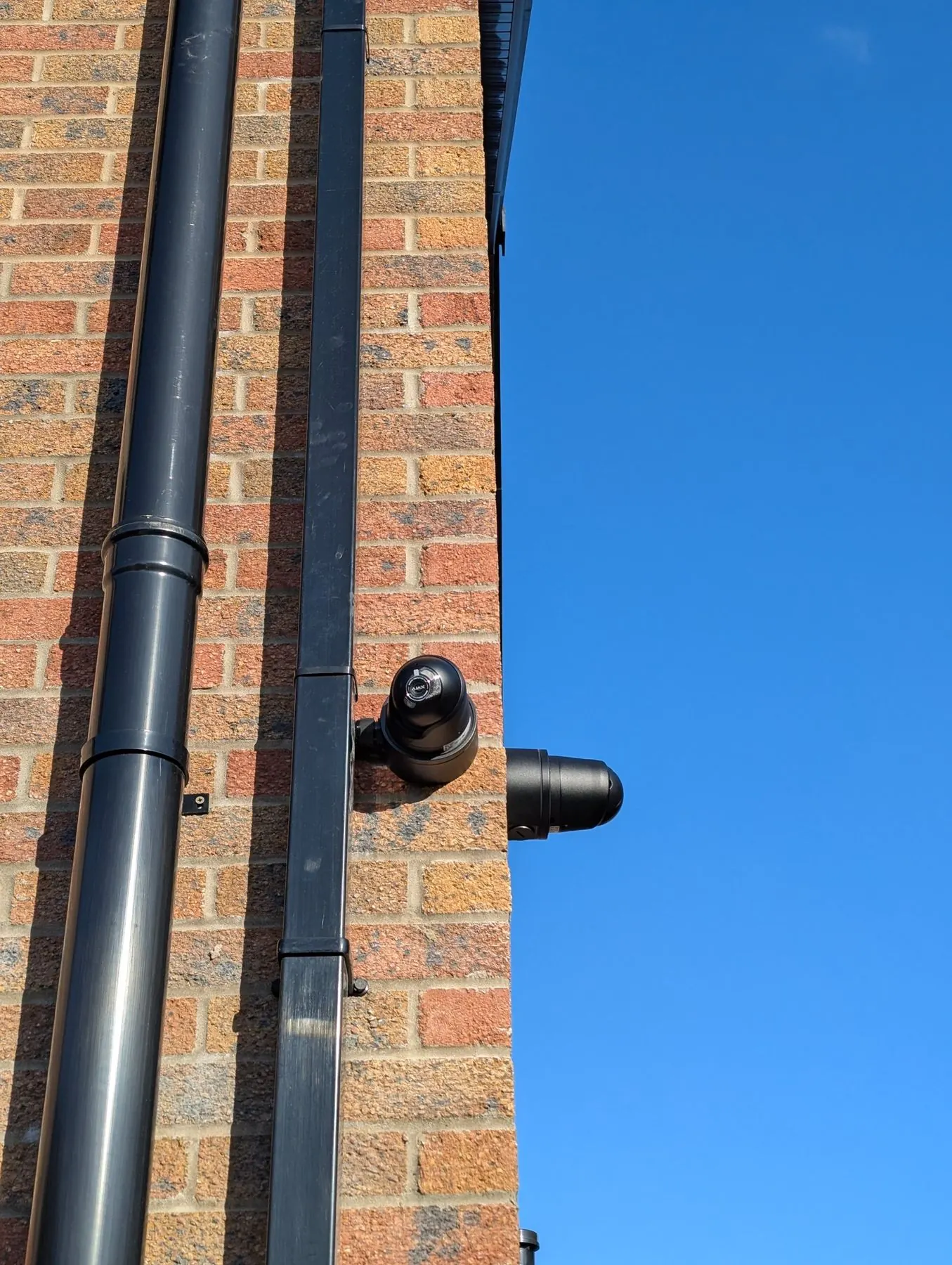 Hikvision external home CCTV camera mounted on a brick wall for residential security.