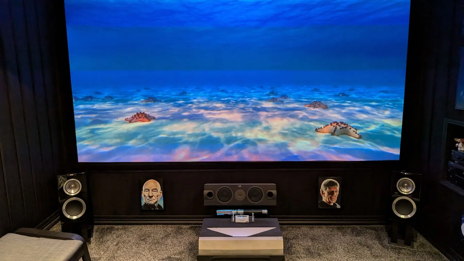 Private home cinema projector screen installation showing a blue scene.