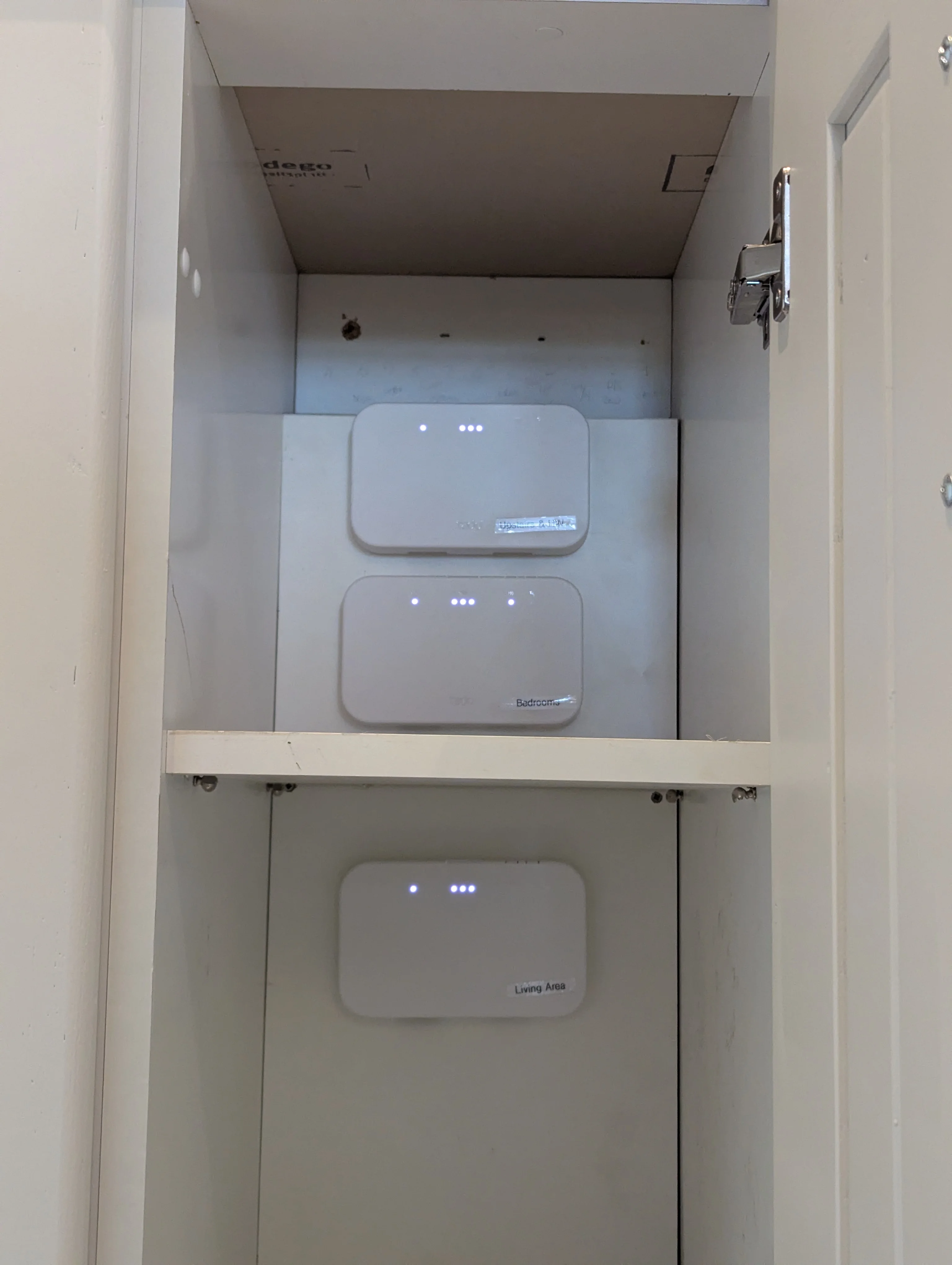 Tado smart heating receiver controls installed neatly inside a home cupboard.