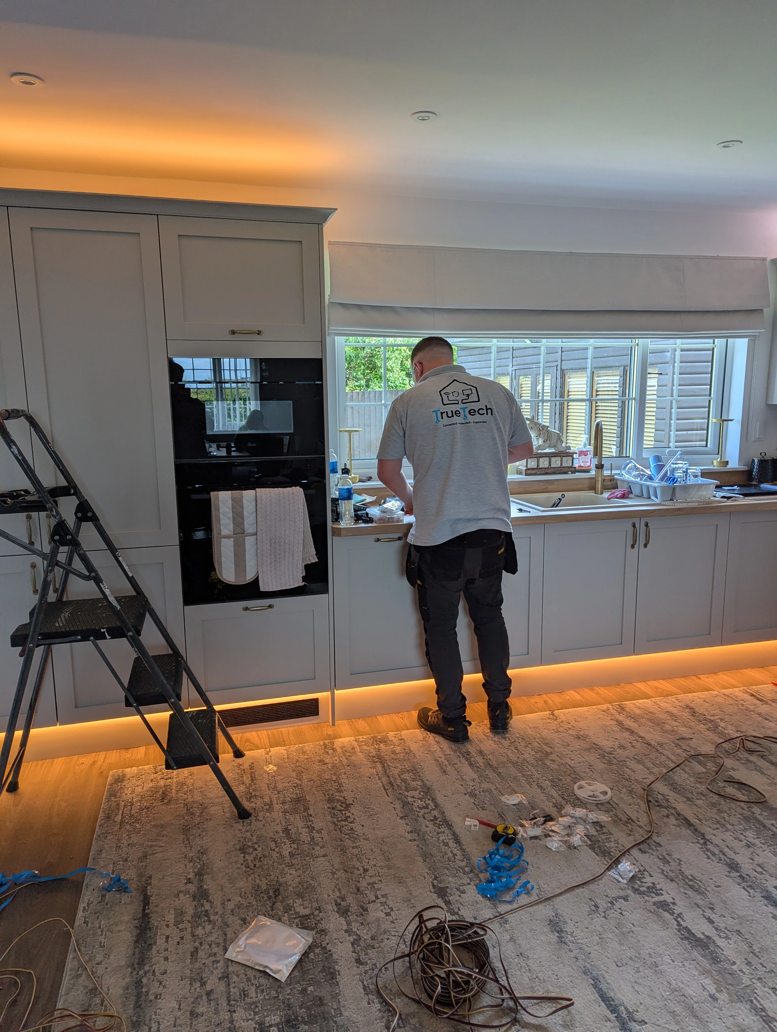 True Tech smart lighting LED strip installation adding warm feature lighting to a kitchen.